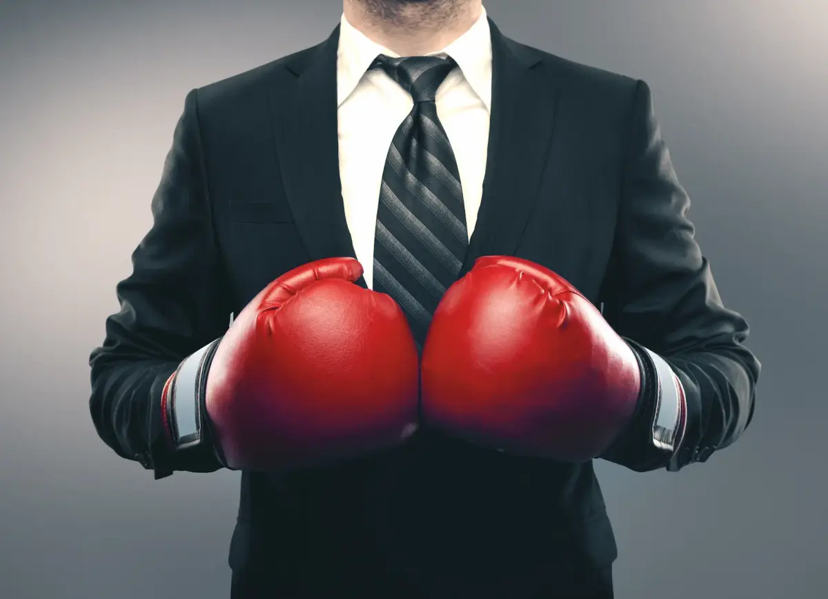 A professional in a suit wearing red boxing gloves